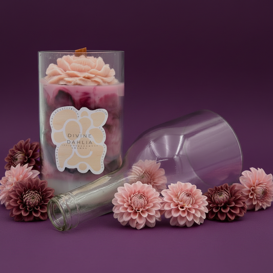 Glass bottle with pink flowers and 'Divine Dahlia' label on a purple background