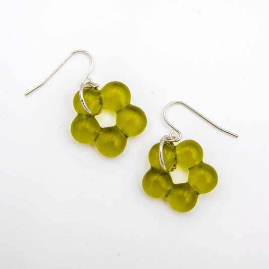 A pair of dangle earrings featuring translucent olive green bead clusters suspended from silver fishhook wires, displayed on a clean white background.