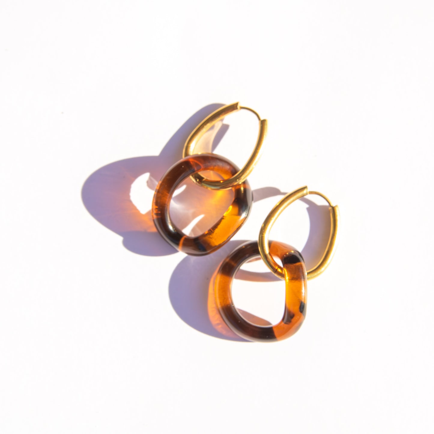 Pair of amber hoop earrings on a white background