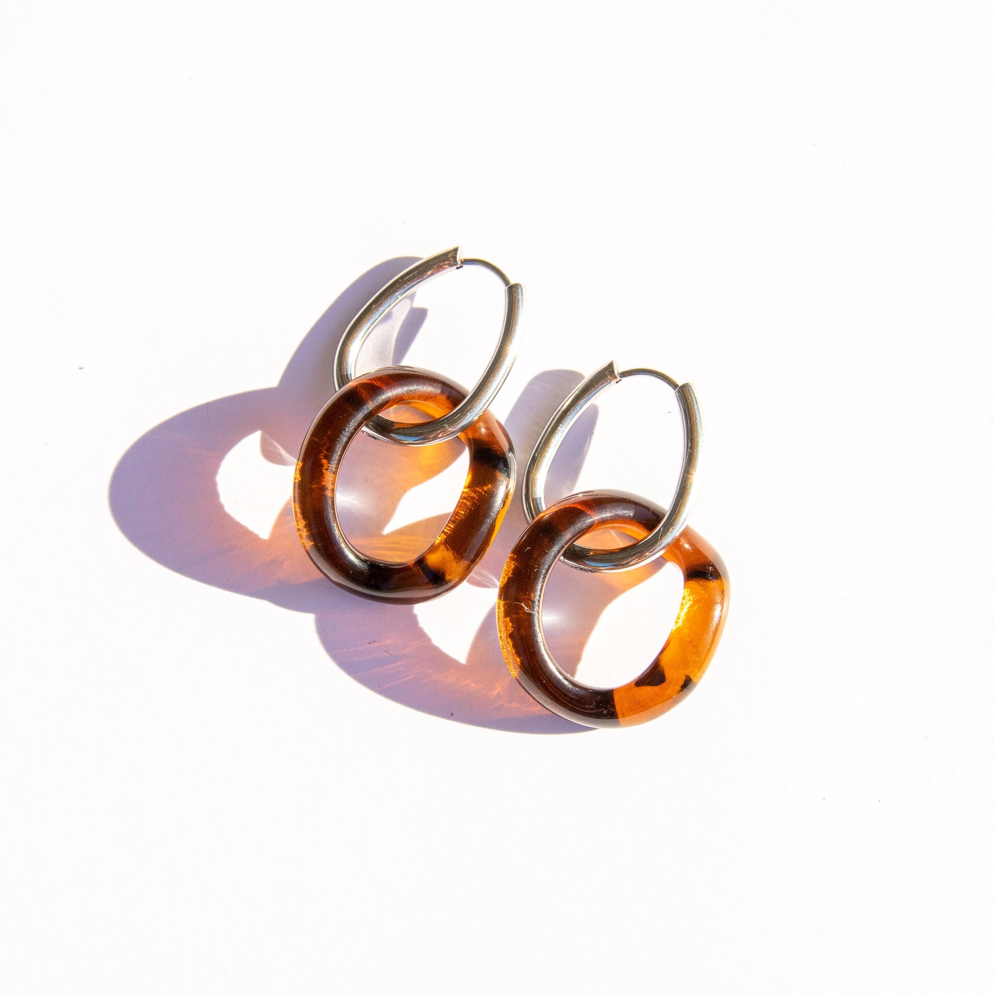 Pair of amber hoop earrings on a white background