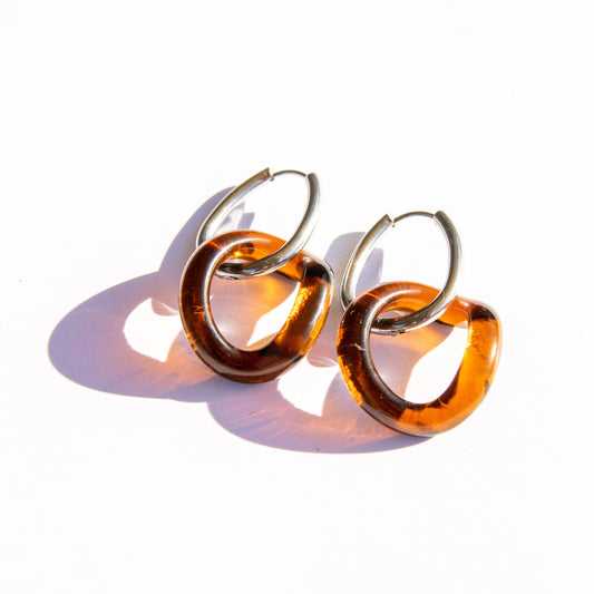 Pair of amber hoop earrings on a white background