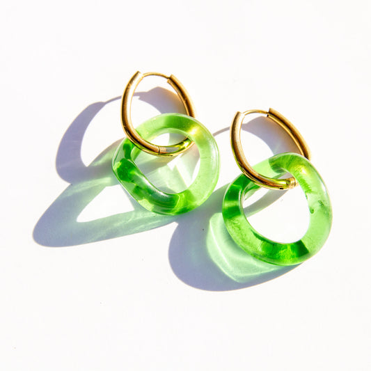 Green hoop earrings with gold accents on a white background