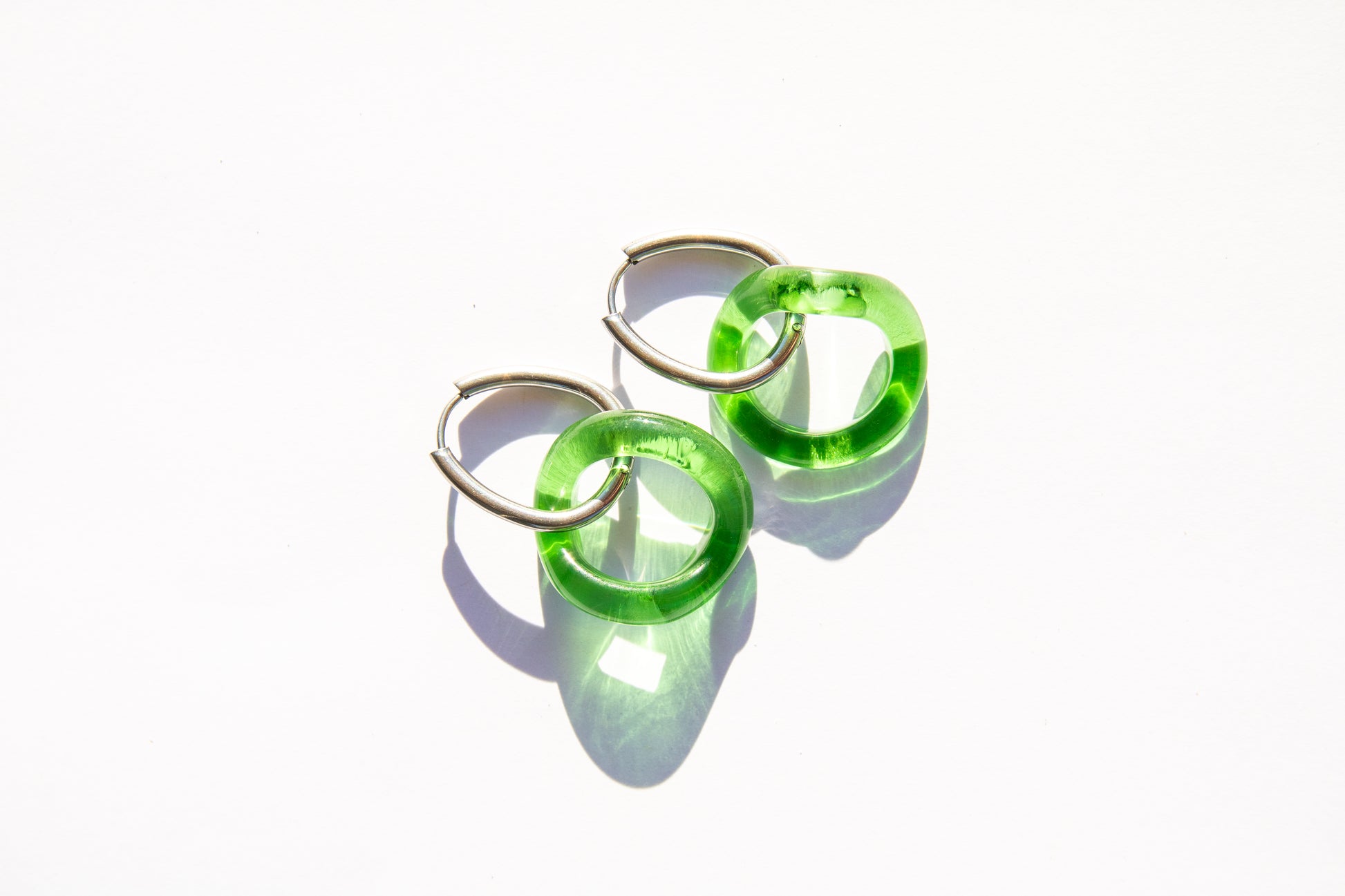 Green hoop earrings on a white background