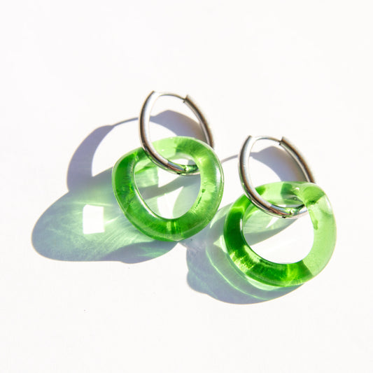 Green hoop earrings on a white background