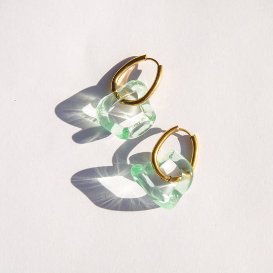 Gold and seafoam glass hoop earrings on a white background