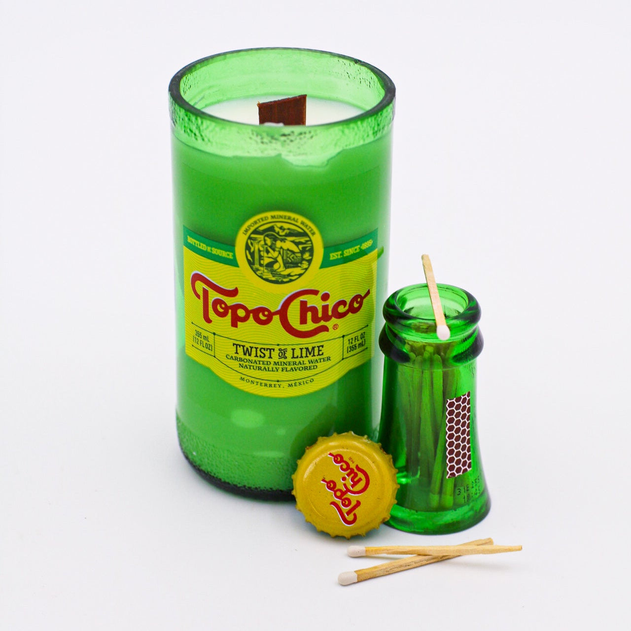 Green Topo Chico bottle candle with accessories on a white background