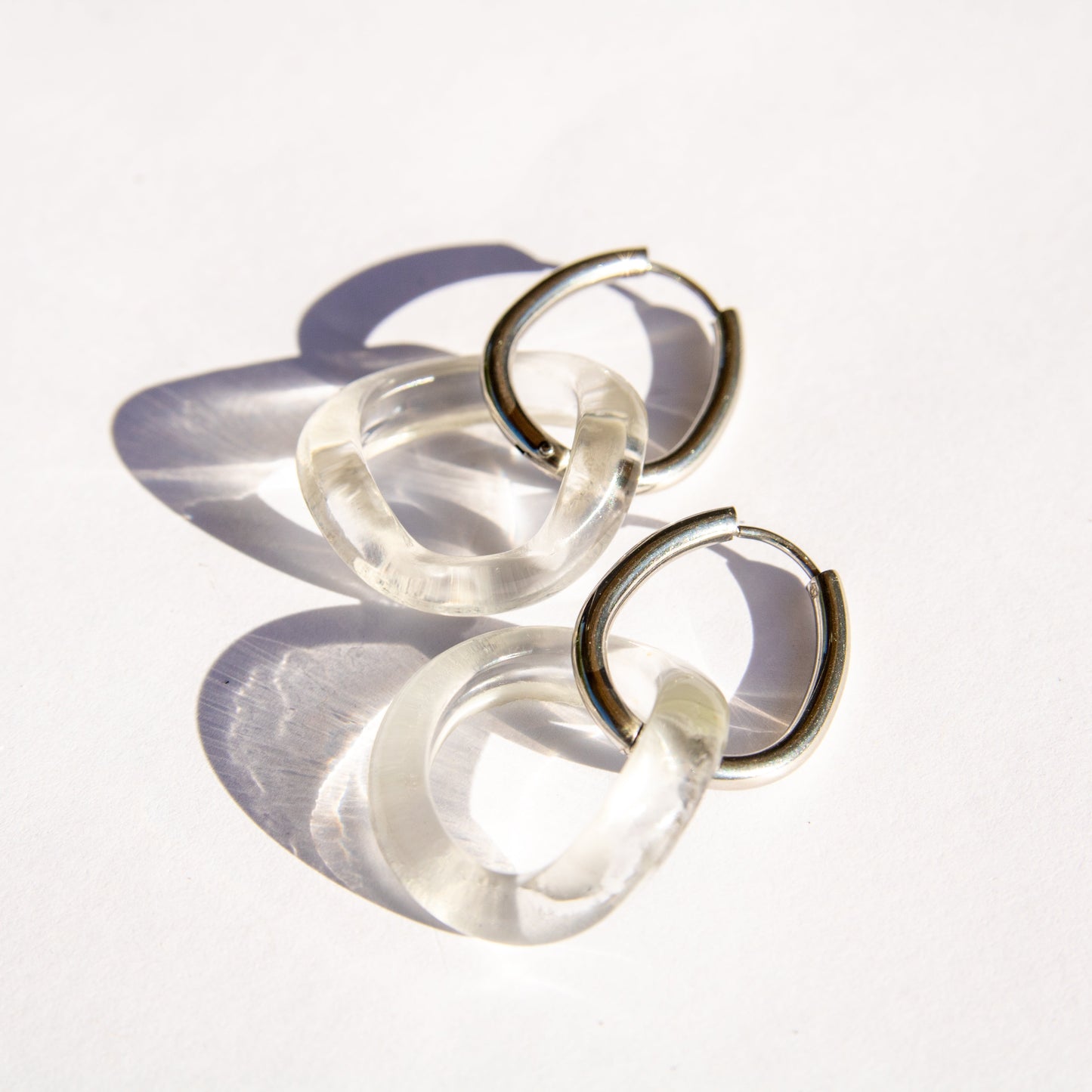 Pair of clear glass hoop earrings on a white background
