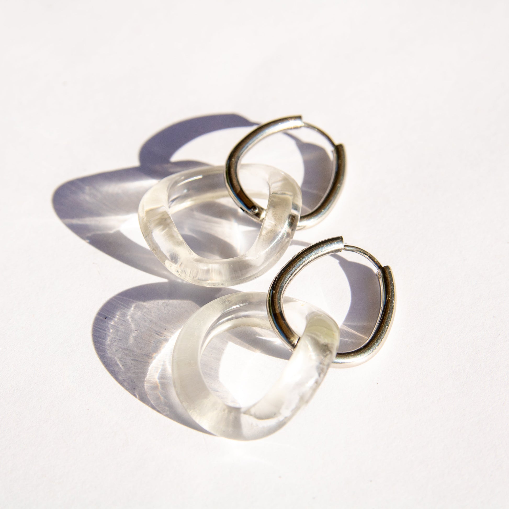 Pair of clear glass hoop earrings on a white background