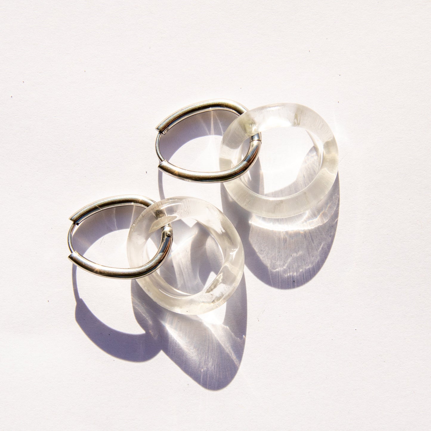 Clear glass hoop  earrings on silver hardware on a white background