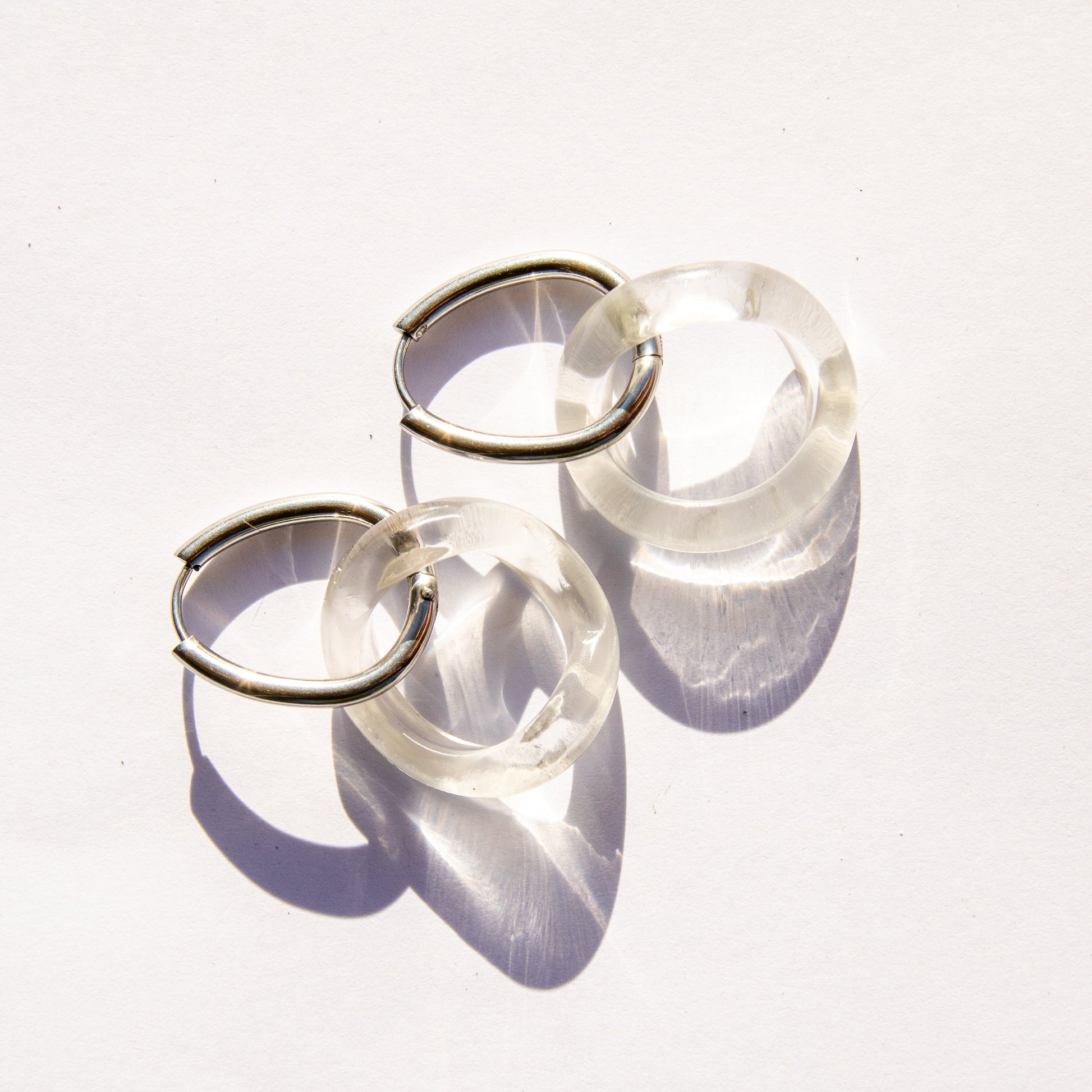 Clear glass hoop  earrings on silver hardware on a white background